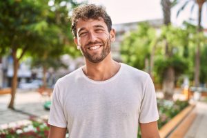 Young hispanic man smiling confident walking at park